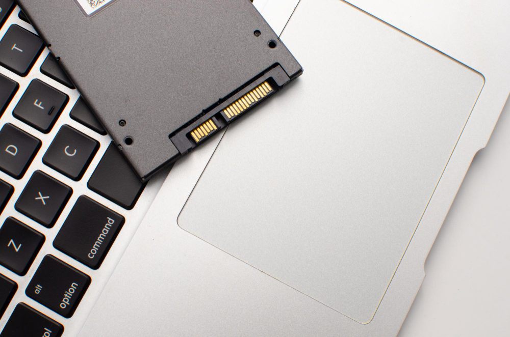 Solid-state drive resting on a laptop keyboard and palm rest