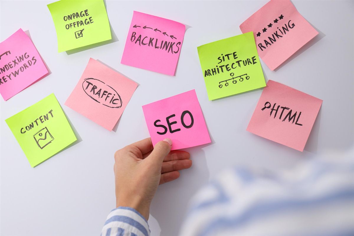 Hand arranging sticky notes about SEO, content and site structure
