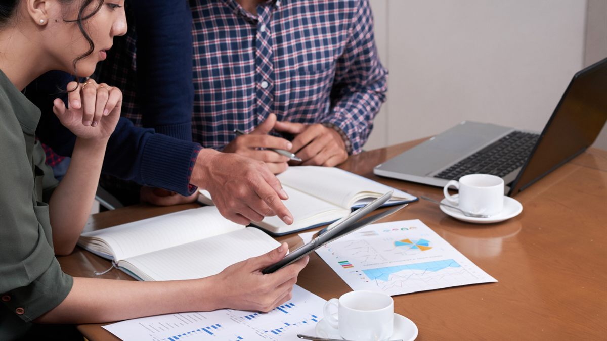 Colleagues reviewing printed charts and notes at a desk