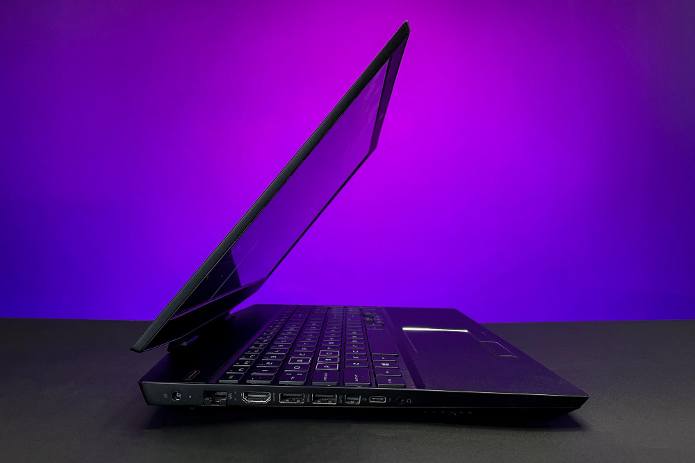 Side profile of an open laptop against purple lighting