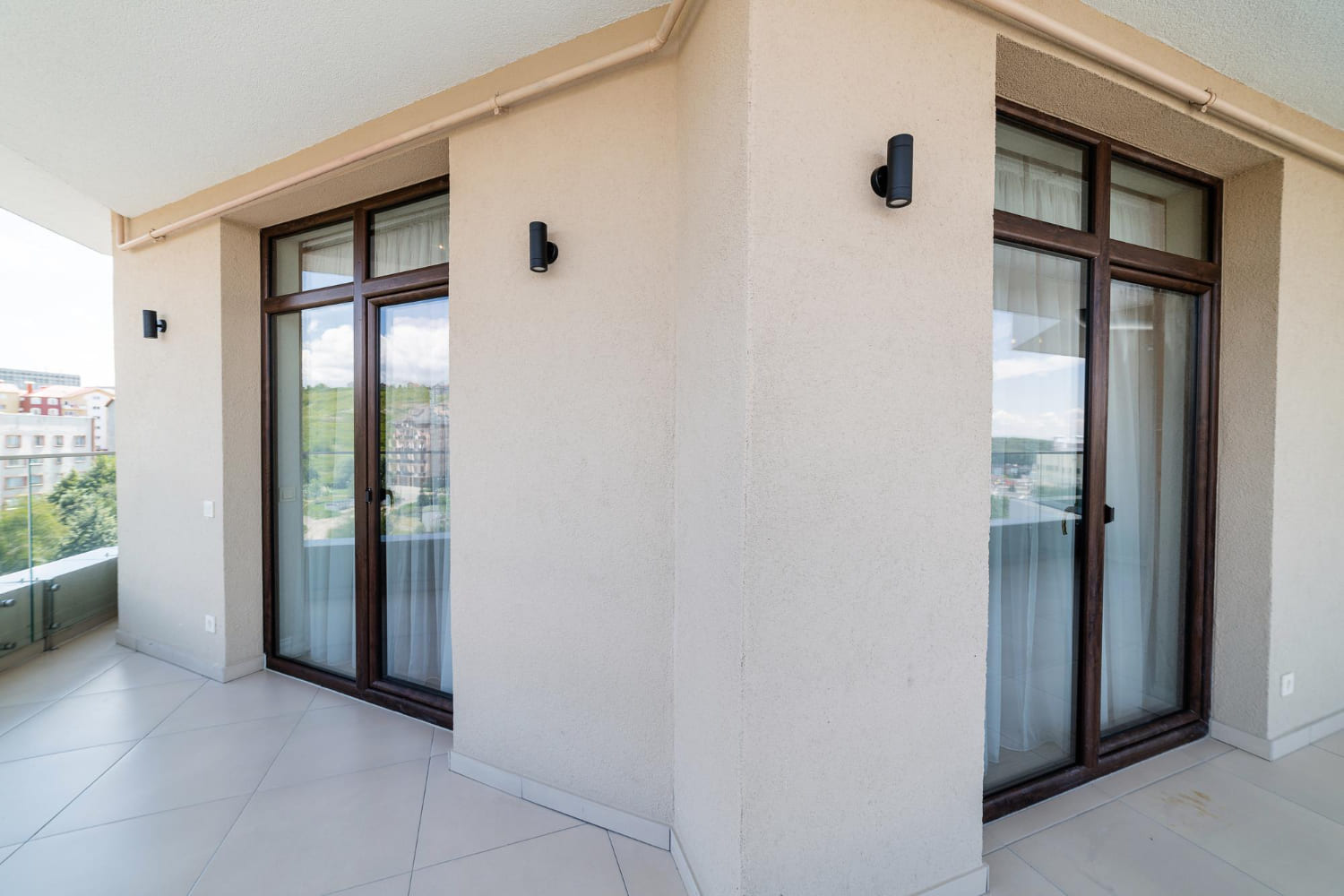 Dark-framed glazed doors opening onto a residential balcony