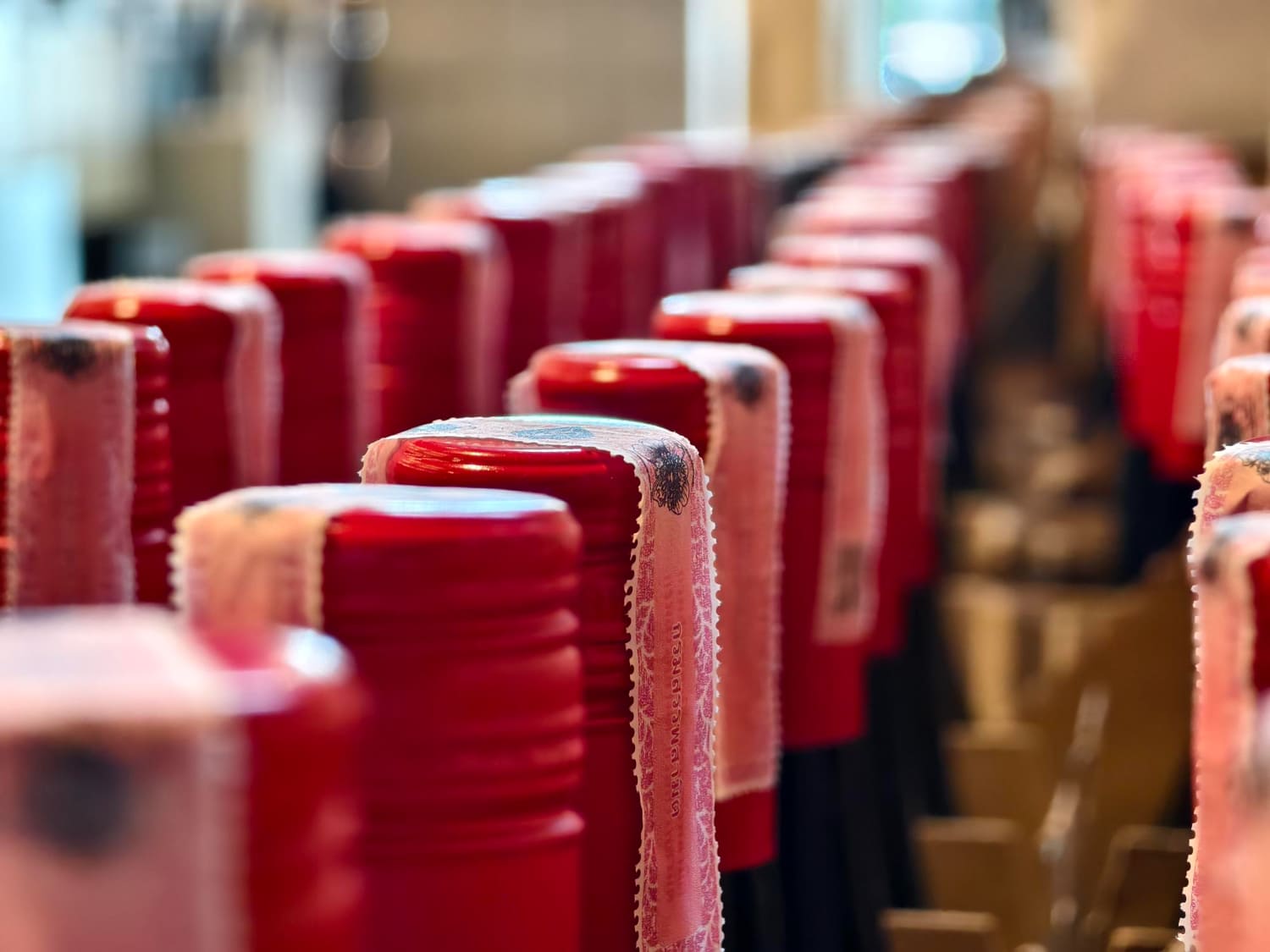Rows of red-capped bottles moving through a packaging line