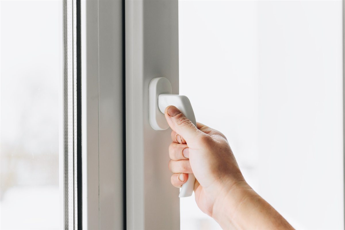 Hand turning a conventional white window handle